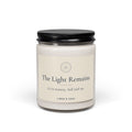 The Light Remains – Gedenkkerze aus Sojawachs, geschlossenes Glas (255 g) mit schwarzem Deckel und cremefarbenem Etikett, vor weißem Hintergrund