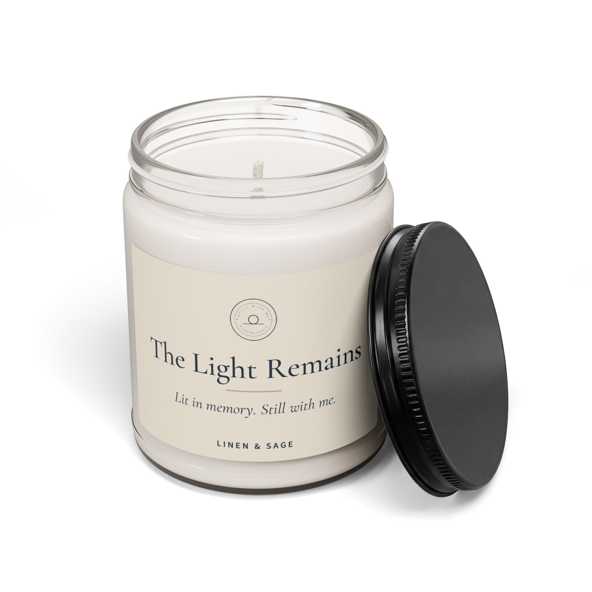 The Light Remains – Sojawachskerze mit abgenommenem Deckel, weißes Wachs und einzelner Docht sichtbar, der schwarze Deckel liegt daneben