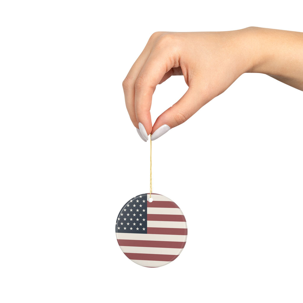 American flag memorial ornament hanging from a hand on its gold string