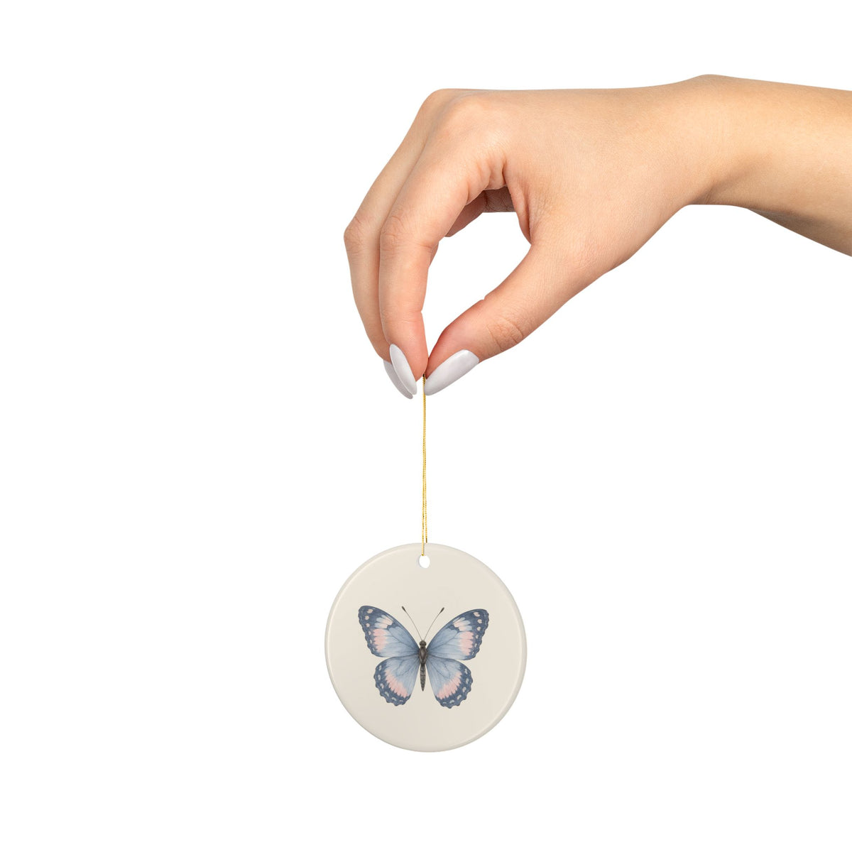 Butterfly memorial ornament hanging from a hand on its gold string