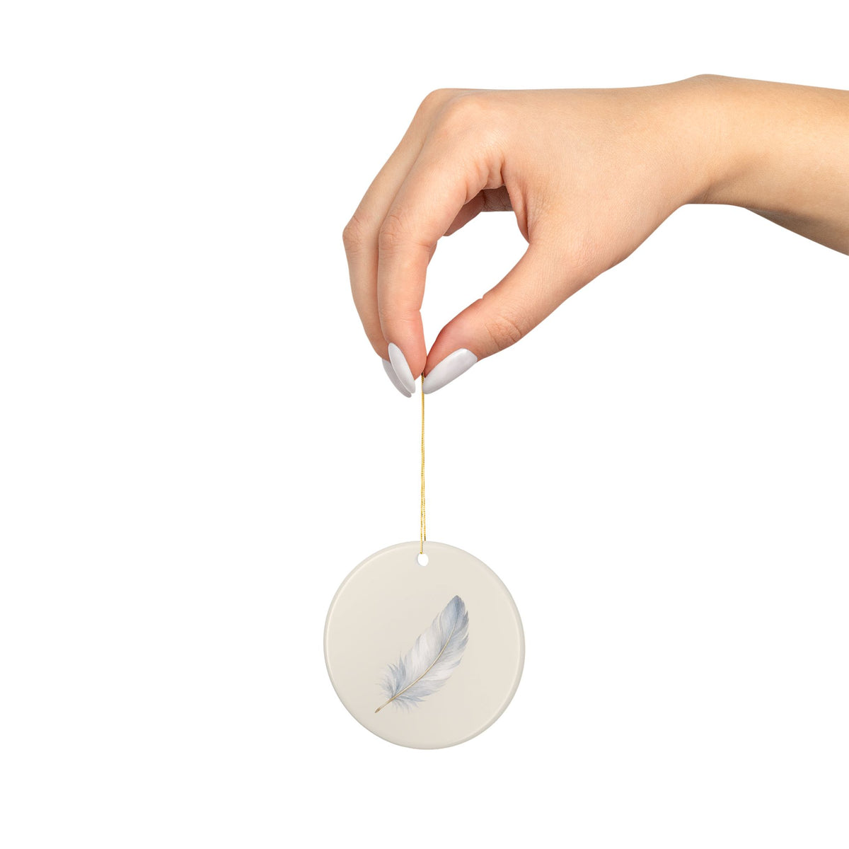 Feather memorial ornament hanging from a hand on its gold string