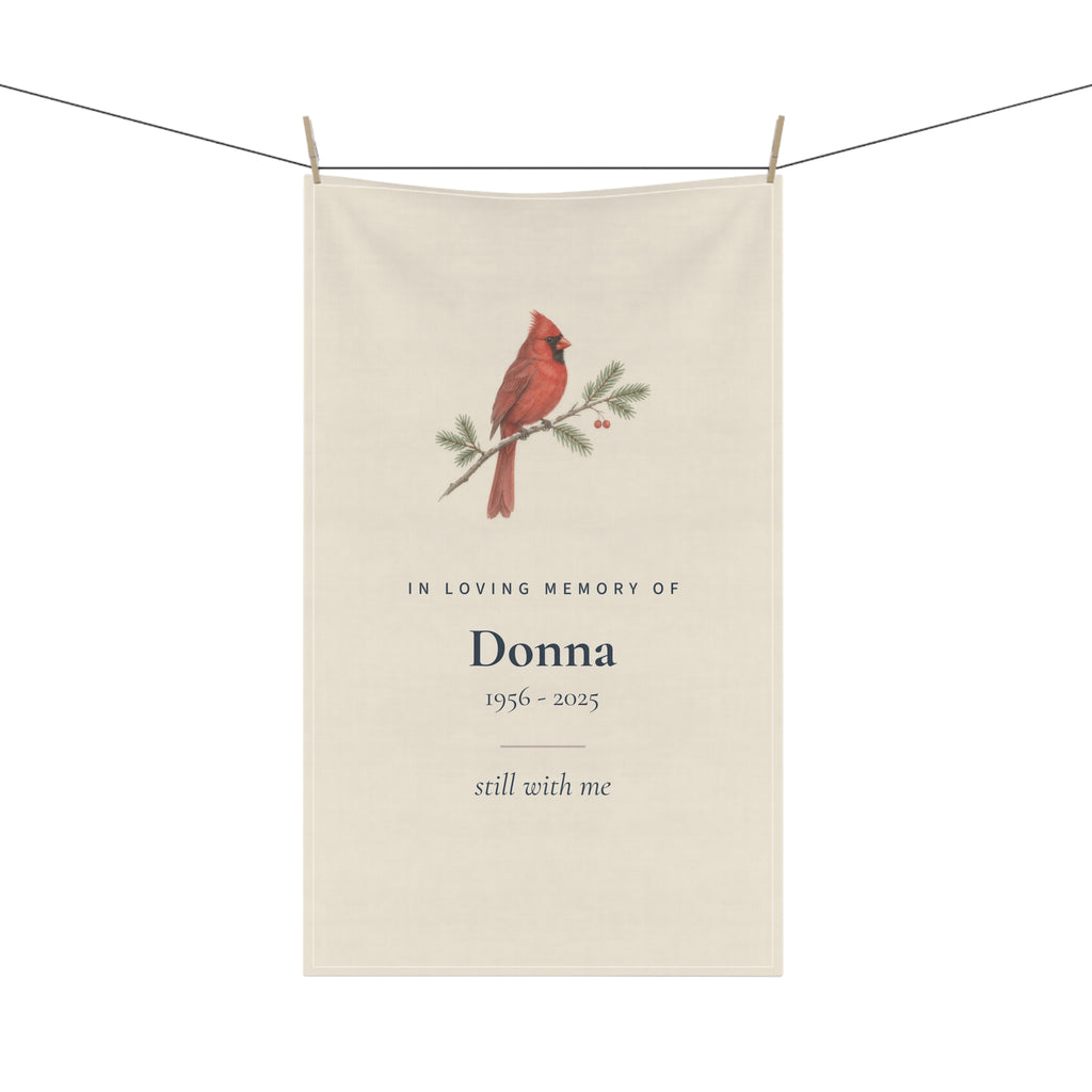 Cardinal memorial tea towel for Donna hanging on a line with wooden pegs