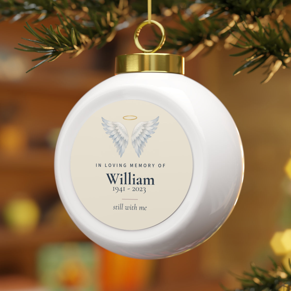 Personalized angel wings memorial ornament with the name William hanging on a Christmas tree