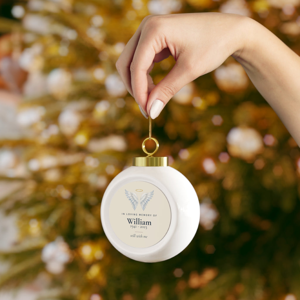 Angel wings memorial ornament with the name William and dates 1941 - 2023 held in hand