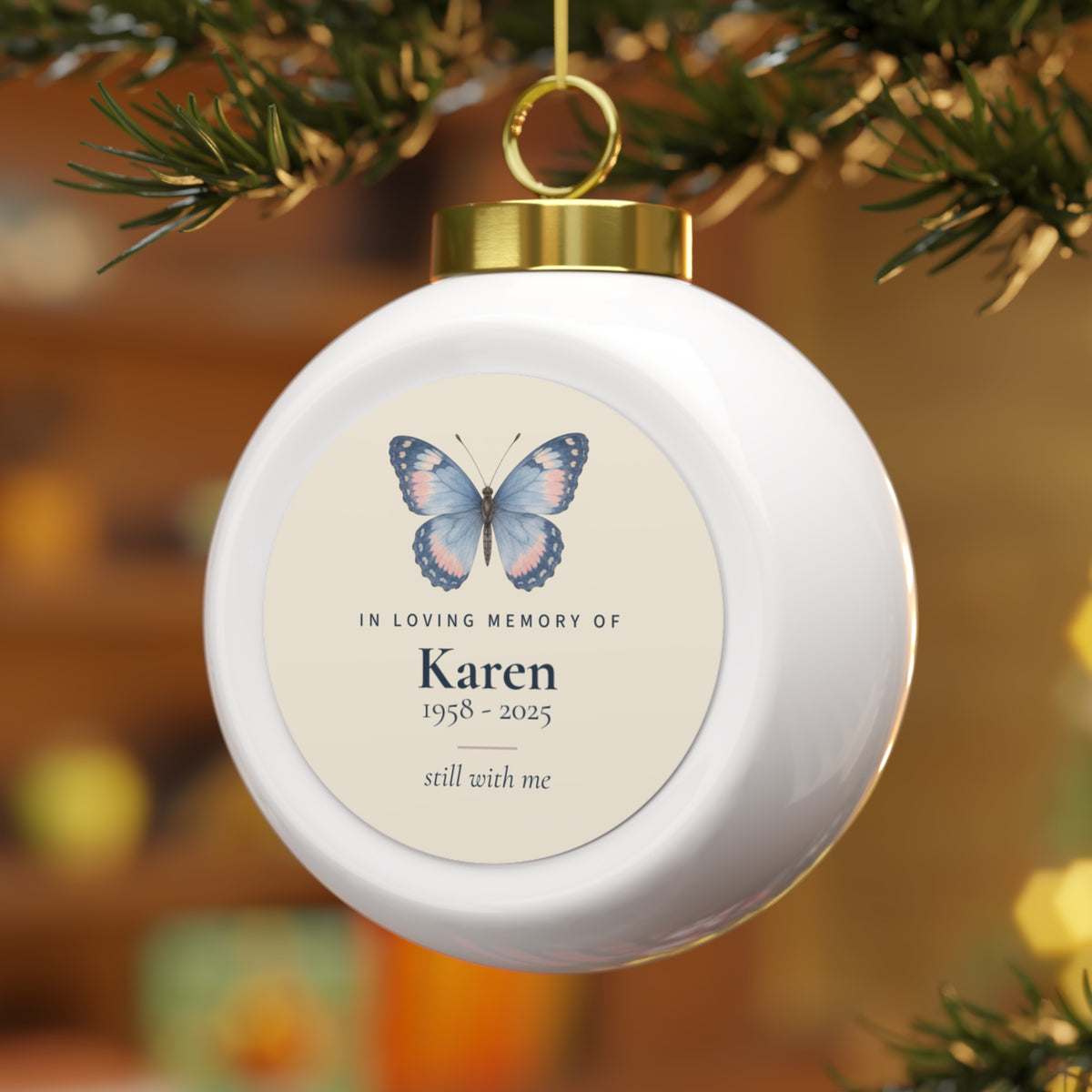 Butterfly memorial Christmas ball for Karen hanging on a lit Christmas tree